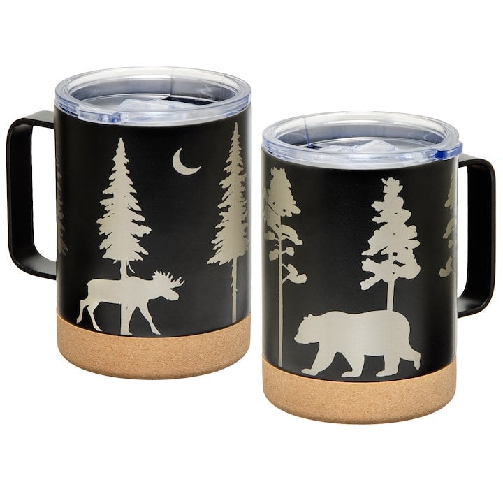 Two black insulated mugs with cork bottoms feature woodland designs of trees, a moon, a moose, and a bear.