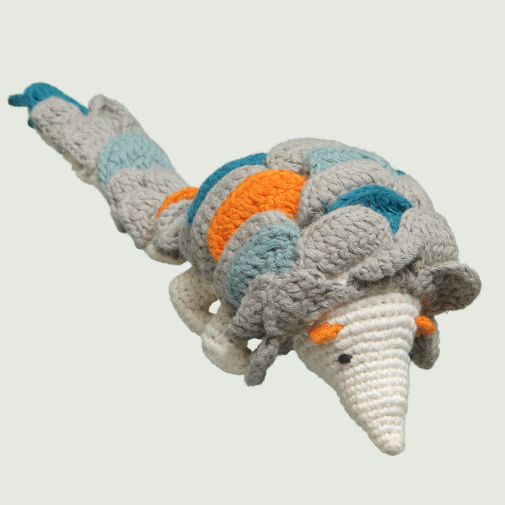 A crocheted pangolin toy with a colorful shell featuring orange, blue, and grey patterns.