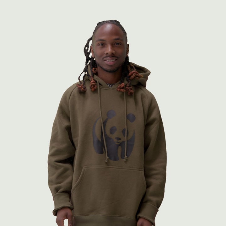 A person wearing a green hoodie with a panda design stands against a light background;
