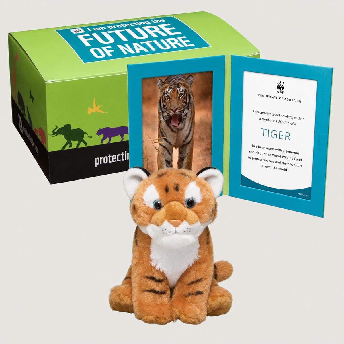 A WWF adoption kit featuring a plush tiger toy, a framed tiger photo, an adoption certificate, and a themed box promoting wildlife conservation.