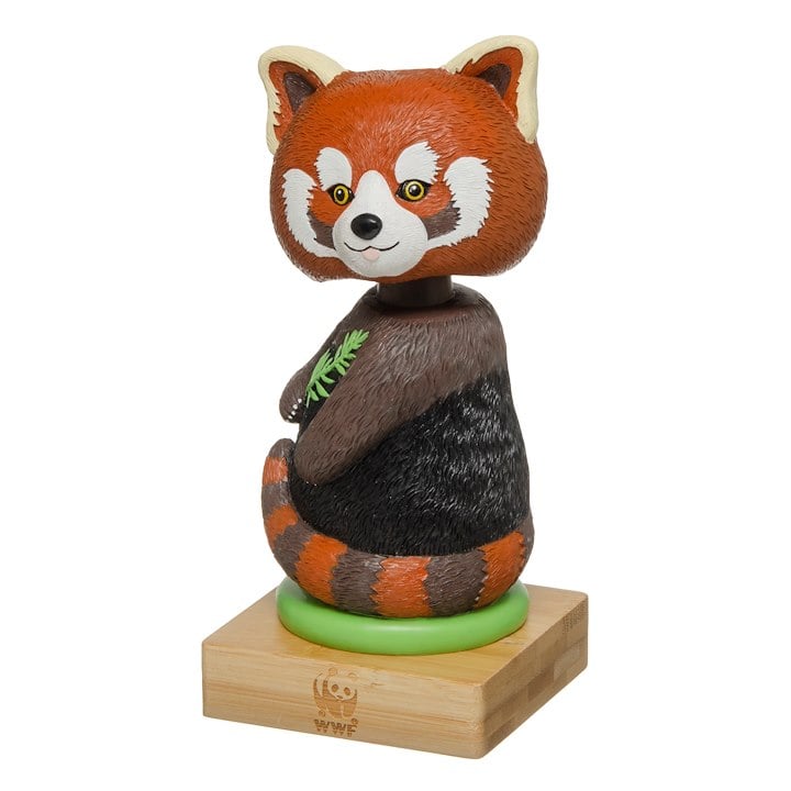 A stylized, cartoonish red panda figurine sitting on a wooden base.