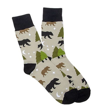 A pair of beige socks with black toes and tops, featuring a pattern of bears, trees, stars, and moons.