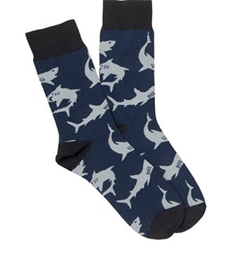 A pair of navy blue socks with a pattern of light gray sharks and black cuffs, heels, and toes.