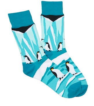 A pair of teal socks featuring a design of penguins and icy landscapes.
